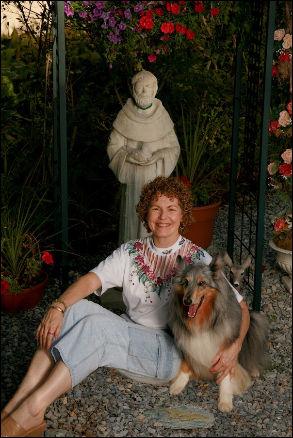 Woman and dog seated under St. Francis statue